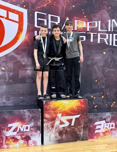 Three young grapplers together on the first-place podium at a Grappling Industries tournament.